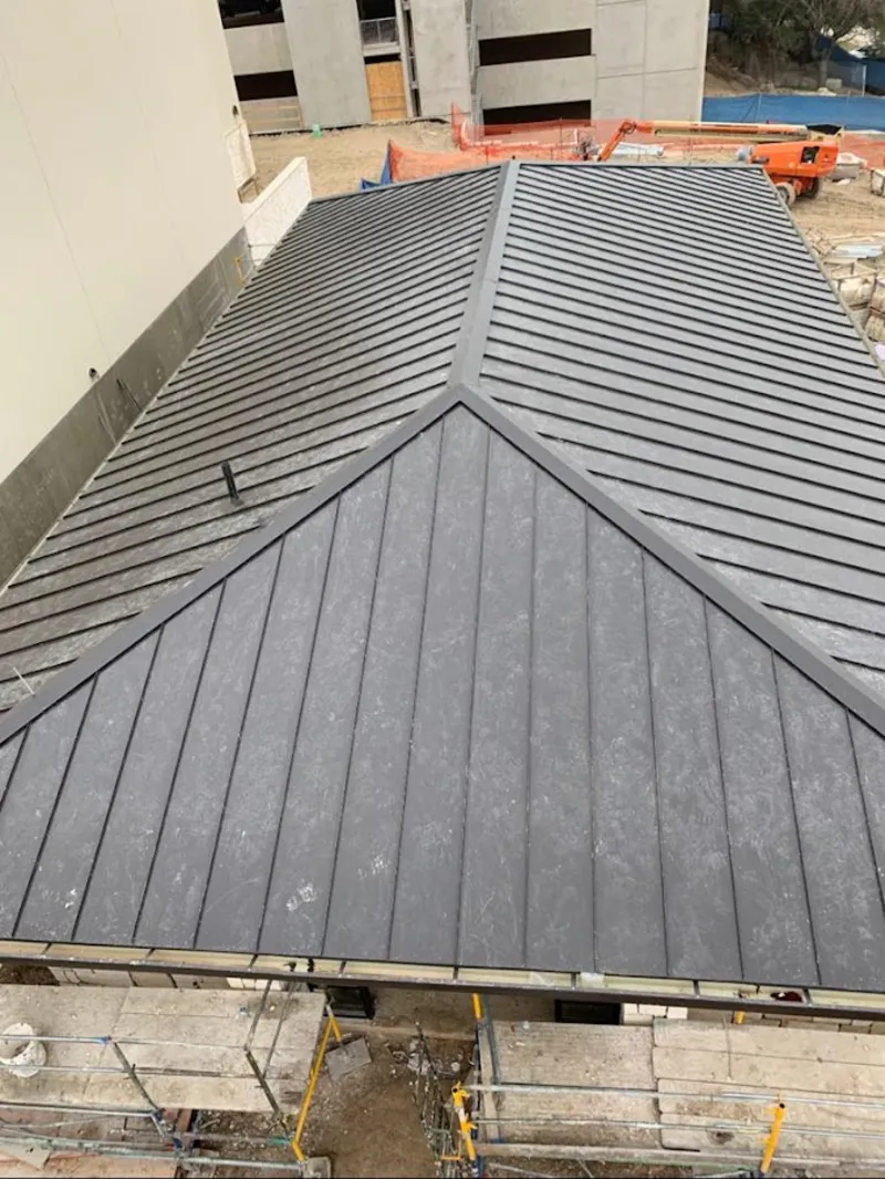 Commercial metal roof construction with crane equipment in Solon