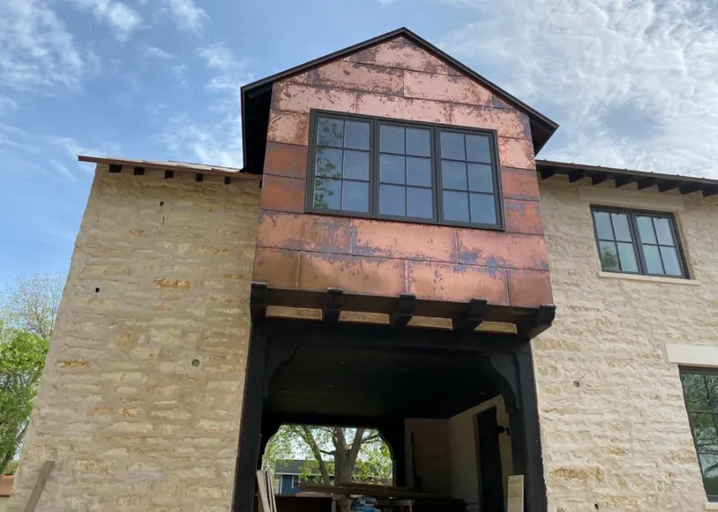Copper metal panel facade on a stone building for Skylight Installation in Solon